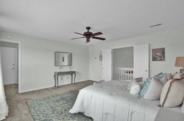 carpeted bedroom featuring ceiling fan and a textured ceiling