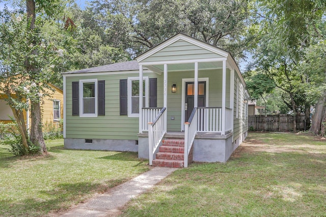 bungalow with covered porch and a front yard