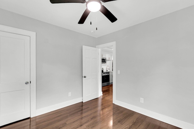 unfurnished bedroom featuring ceiling fan, dark hardwood / wood-style floors, and sink