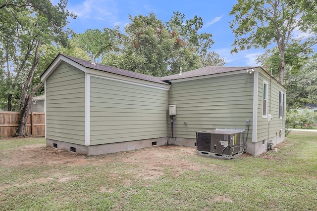 view of home's exterior featuring central AC unit and a lawn