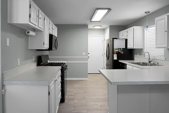 kitchen featuring sink, black appliances, hanging light fixtures, kitchen peninsula, and white cabinets