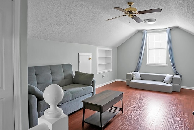 living room with built in features, wood-type flooring, lofted ceiling, ceiling fan, and a textured ceiling