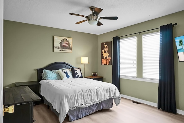 bedroom with ceiling fan and a textured ceiling