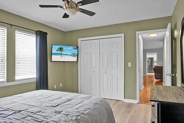 bedroom featuring light hardwood / wood-style flooring, a closet, and ceiling fan