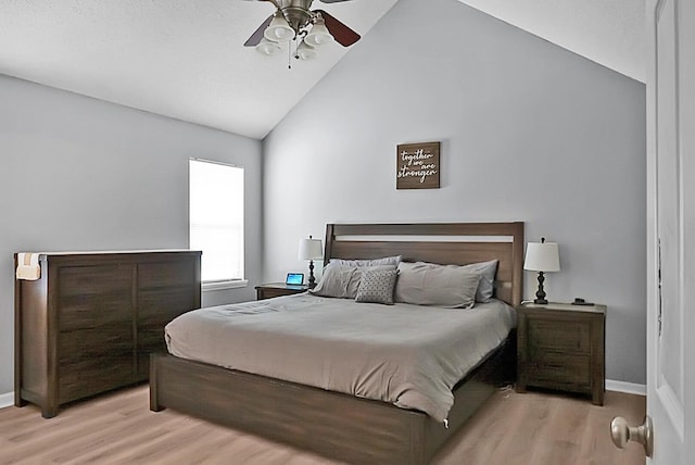 bedroom with ceiling fan, lofted ceiling, and light hardwood / wood-style floors