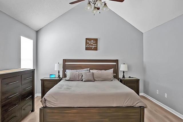 bedroom with ceiling fan, lofted ceiling, and light hardwood / wood-style floors