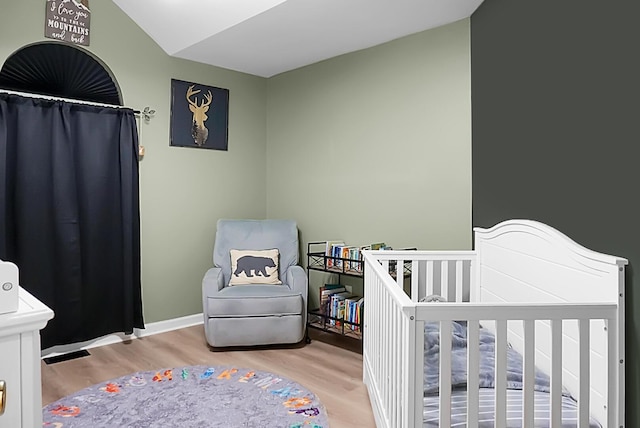 bedroom with lofted ceiling and light hardwood / wood-style floors