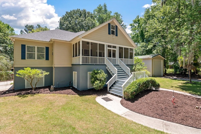 2649 Starfish Dr, Johns Island, SC 29455 - view of front of property featuring a sunroom, stairway, an outbuilding, a front yard, and a shingled roof