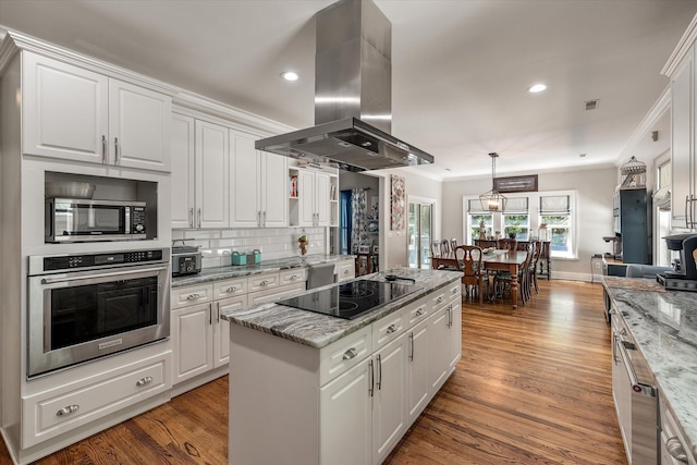 2649 Starfish Dr, Johns Island, SC 29455 - kitchen featuring appliances with stainless steel finishes, island range hood, a center island, white cabinetry, and light wood-style flooring