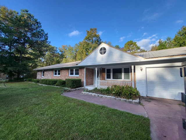 ranch-style home featuring a front lawn, covered porch, and a garage