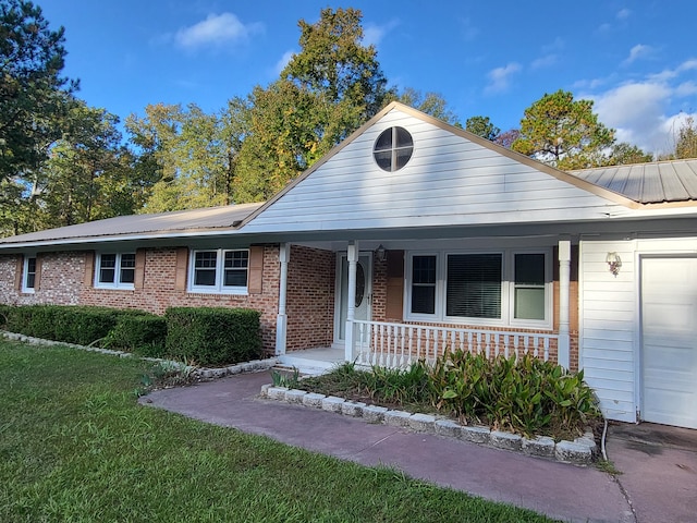 view of front of property featuring a porch, a front lawn, and a garage