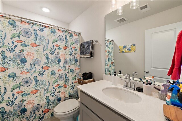 bathroom featuring vanity, toilet, and walk in shower