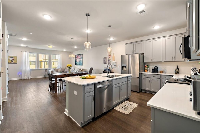 kitchen with gray cabinetry, sink, an island with sink, and appliances with stainless steel finishes