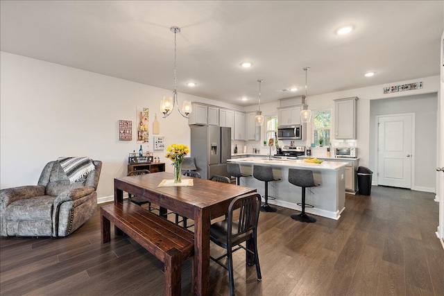 dining space with dark wood-type flooring and an inviting chandelier