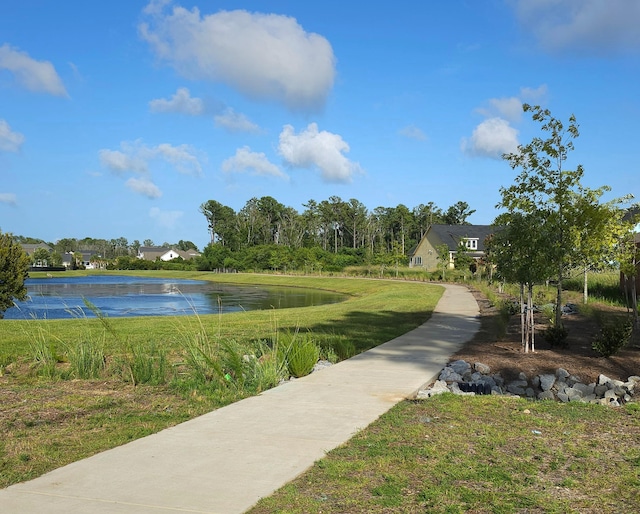 view of home's community with a water view and a yard