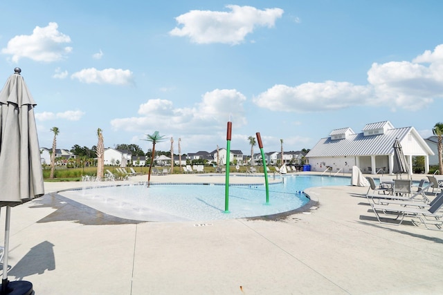 view of pool featuring pool water feature and a patio