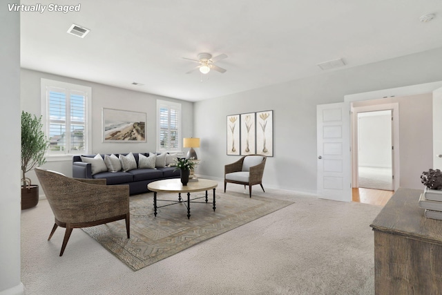 carpeted living room with ceiling fan