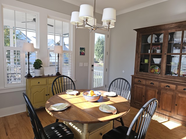 dining space featuring hardwood / wood-style flooring, crown molding, and an inviting chandelier