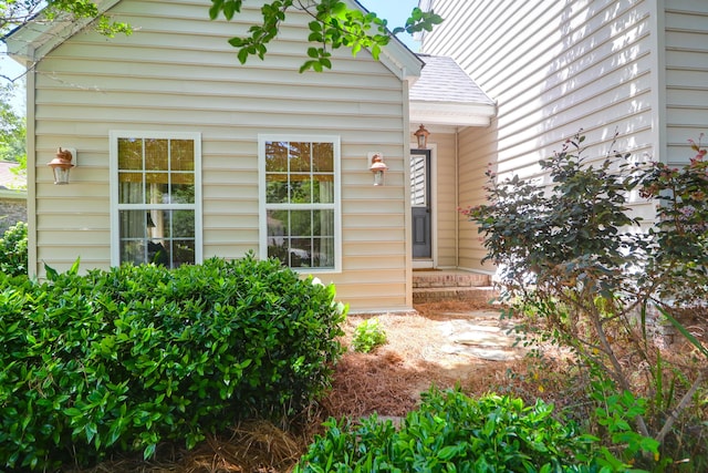 doorway to property with a shingled roof