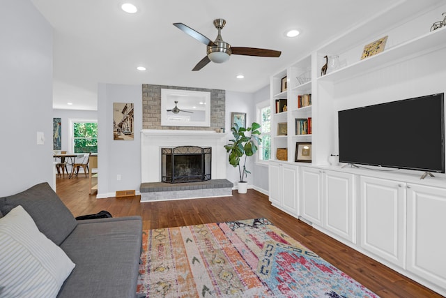 living room with a ceiling fan, visible vents, a fireplace, recessed lighting, and dark wood-type flooring