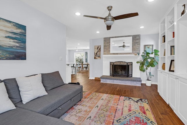 living room featuring recessed lighting, ceiling fan, wood finished floors, and a fireplace