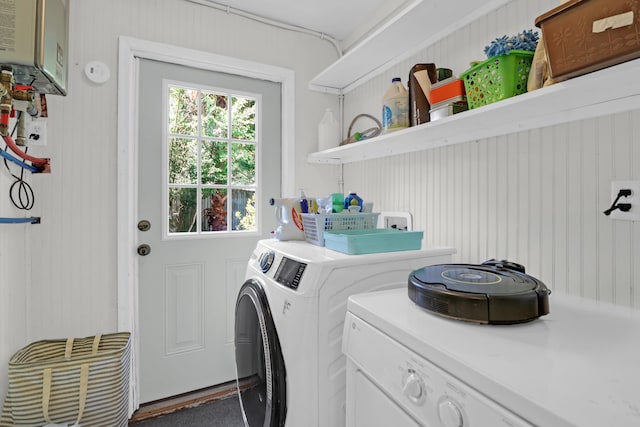 clothes washing area with separate washer and dryer, laundry area, and water heater