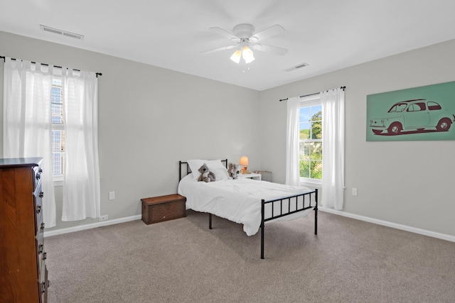 carpeted bedroom featuring a ceiling fan, baseboards, and visible vents