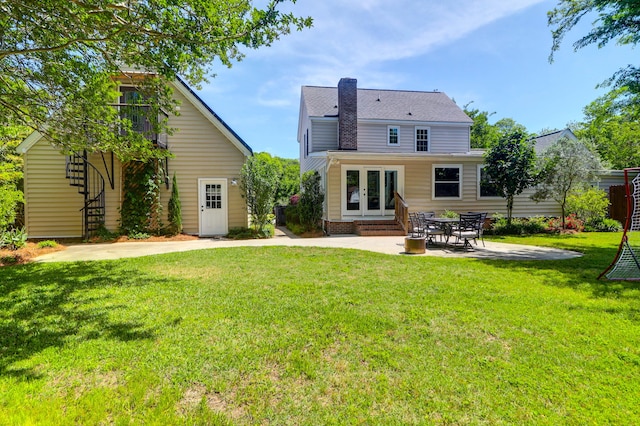 back of house featuring french doors, a lawn, a patio area, and roof with shingles