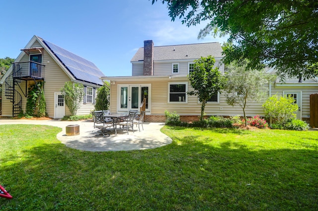 rear view of house featuring a chimney, french doors, a lawn, stairway, and a patio