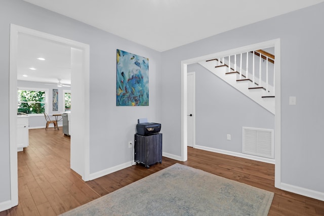 spare room with visible vents, stairs, wood finished floors, baseboards, and recessed lighting