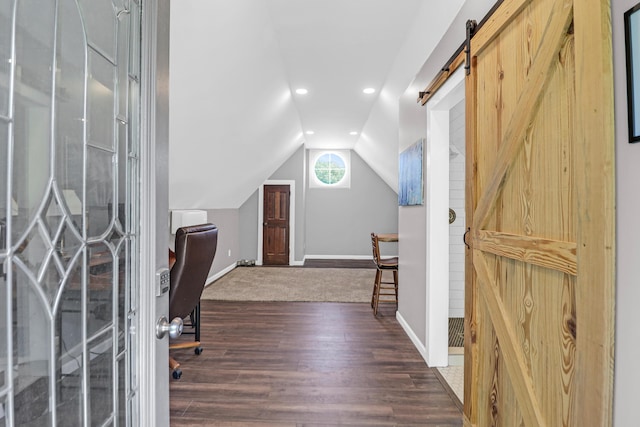 unfurnished office featuring lofted ceiling, wood finished floors, baseboards, recessed lighting, and a barn door