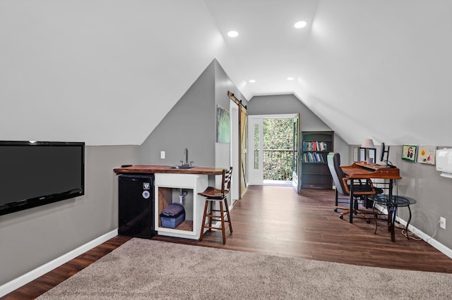 home office featuring lofted ceiling, wood finished floors, baseboards, recessed lighting, and a sink