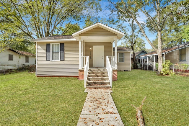 bungalow-style home featuring a porch, a front lawn, and fence