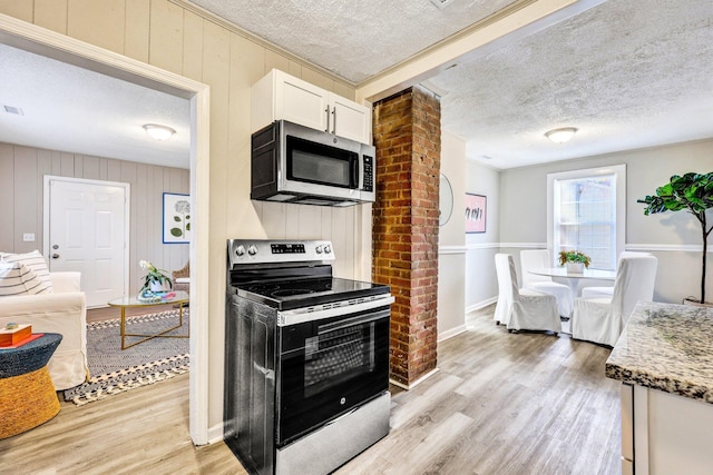 2674 Houston St, North Charleston, SC 29405 - kitchen featuring appliances with stainless steel finishes, light wood-type flooring, a textured ceiling, white cabinetry, and light stone counters