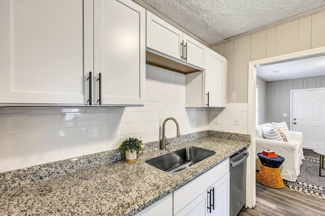 2674 Houston St, North Charleston, SC 29405 - kitchen with a sink, dishwasher, wood finished floors, white cabinetry, and light stone counters