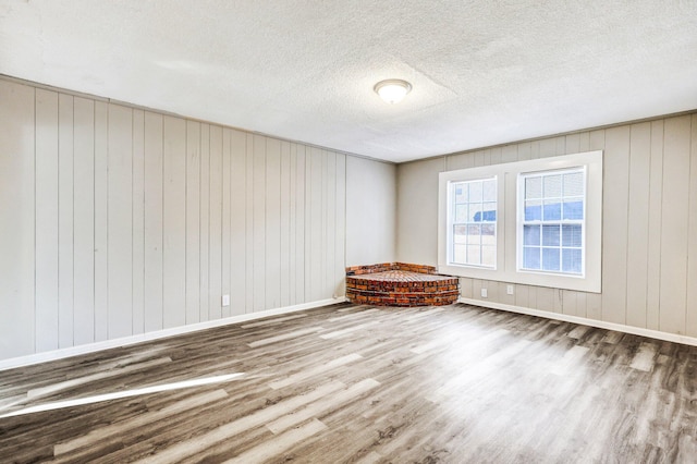 2674 Houston St, North Charleston, SC 29405 - unfurnished room featuring wood finished floors, wood walls, baseboards, and a textured ceiling