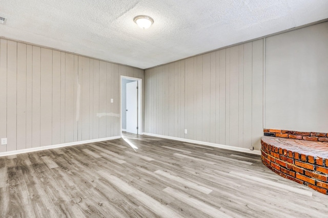 2674 Houston St, North Charleston, SC 29405 - spare room featuring wood finished floors, a textured ceiling, and wood walls