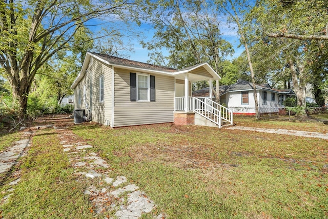 bungalow-style home with central air condition unit and a front lawn