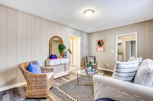 2674 Houston St, North Charleston, SC 29405 - living room featuring wood finished floors, baseboards, a textured ceiling, and wooden walls
