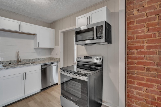 kitchen with a sink, stainless steel appliances, and white cabinetry