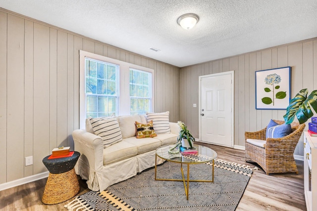 2674 Houston St, North Charleston, SC 29405 - living room with wood finished floors, baseboards, a textured ceiling, and wooden walls