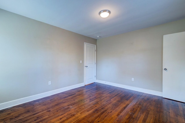 unfurnished room with dark wood finished floors and baseboards