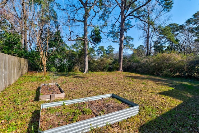 view of yard featuring fence and a garden