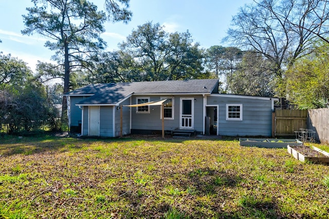 view of front of property with a front yard, a garden, fence, and entry steps