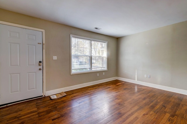 foyer entrance with baseboards, visible vents, and dark wood-type flooring