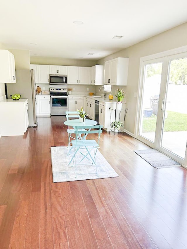 1350 Pinyon Pine Dr, Ladson, SC 29456 - kitchen featuring stainless steel appliances, dark wood-type flooring, light countertops, and white cabinets