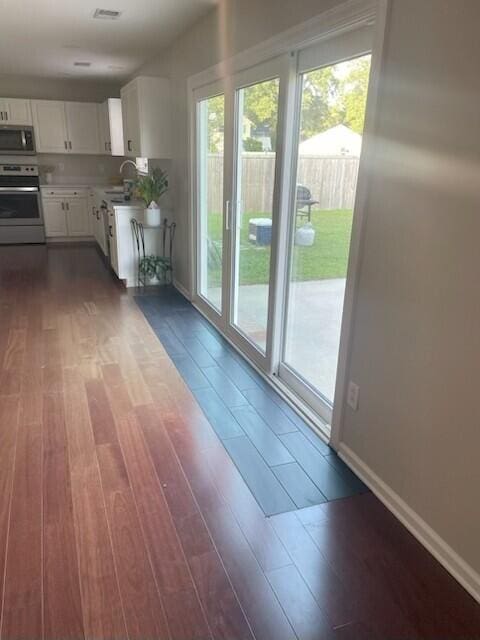 1350 Pinyon Pine Dr, Ladson, SC 29456 - kitchen featuring stainless steel appliances, dark wood-style flooring, white cabinets, and light countertops