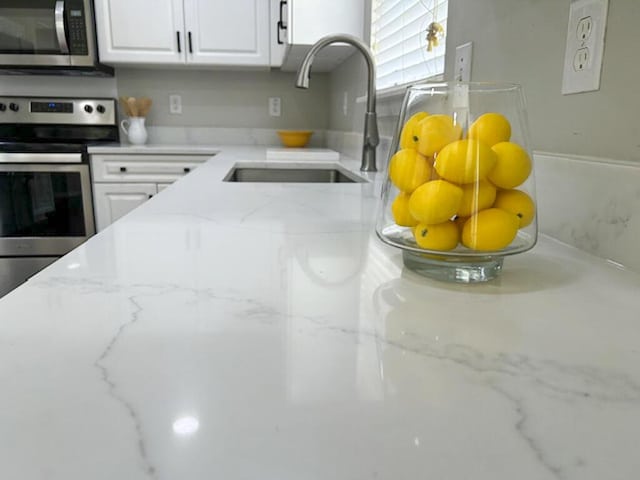 1350 Pinyon Pine Dr, Ladson, SC 29456 - kitchen featuring stainless steel appliances, white cabinets, and light stone counters