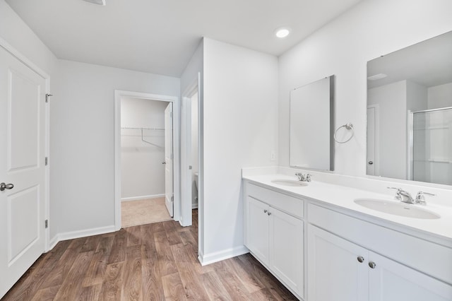 491 Cedarview Rd, Summerville, SC 29486 - bathroom with double vanity, a shower with shower door, a walk in closet, wood finished floors, and baseboards