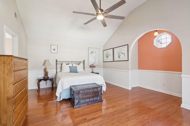 bedroom featuring arched walkways, visible vents, ceiling fan, wood finished floors, and high vaulted ceiling